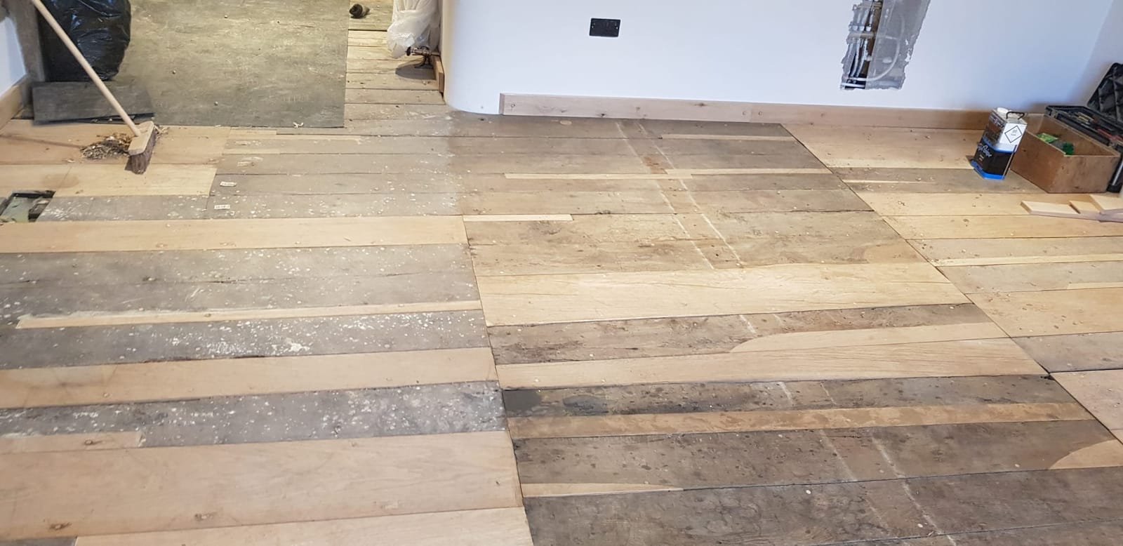 Reclaimed oak floor with exposed ceiling beams during fit-out