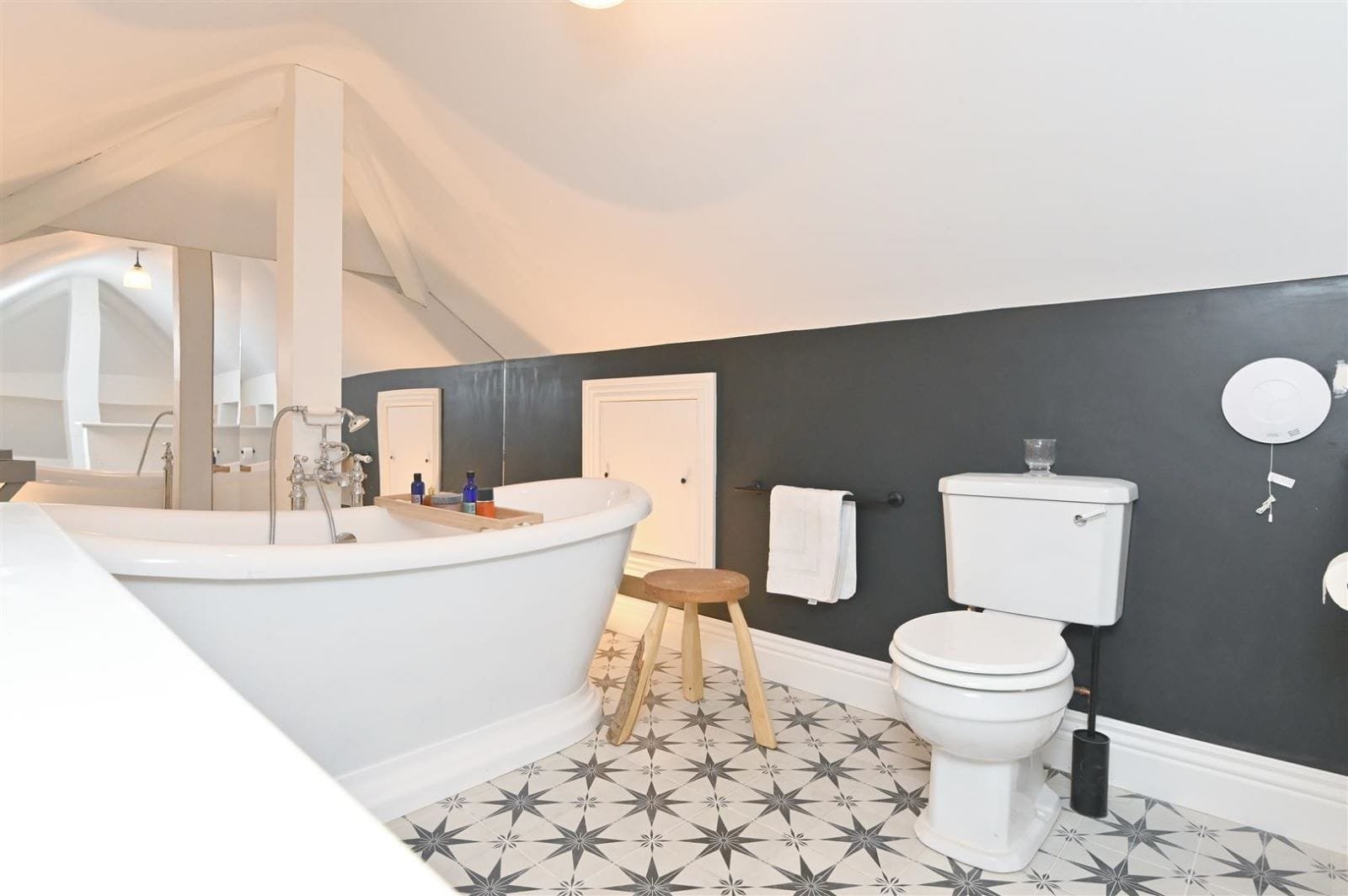 Loft bathroom with freestanding bath and dark feature wall